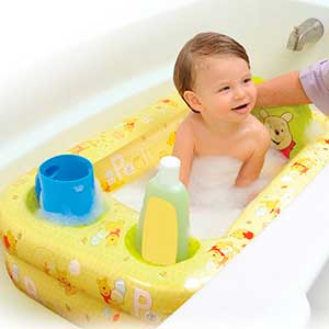 baby being washed in an inflatable baby bath tub