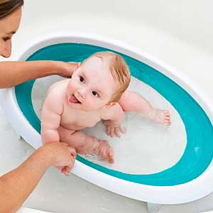 baby being washed in fold up bath tub