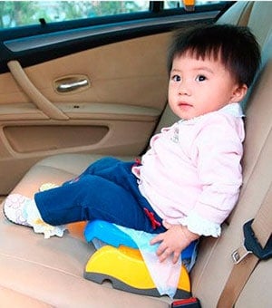 baby using travel potty in the back seat of the car