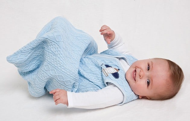 smiling baby wearing a sleep sack
