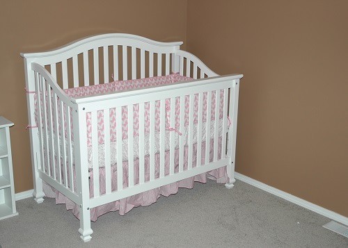 White crib with mattress inside