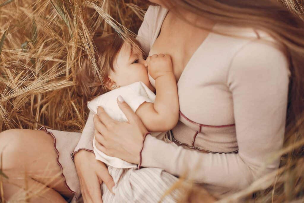 Mother with cute daughter. Mom breastfeeding her little daughter