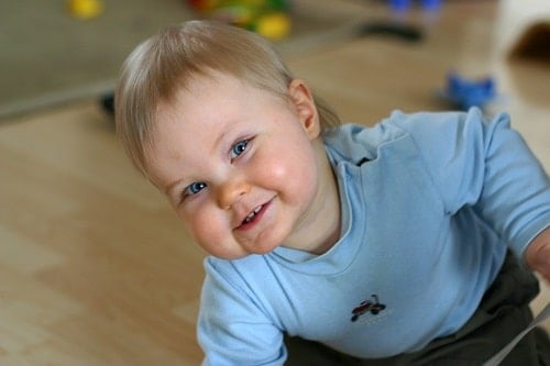 Baby in livingroom wearing blue jacket