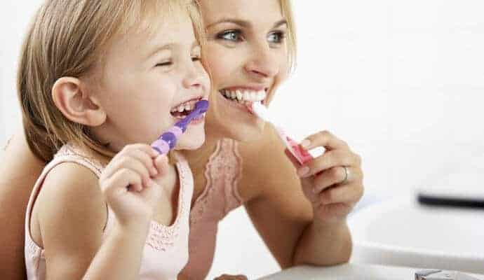 mother and her baby girl brushing their teeth