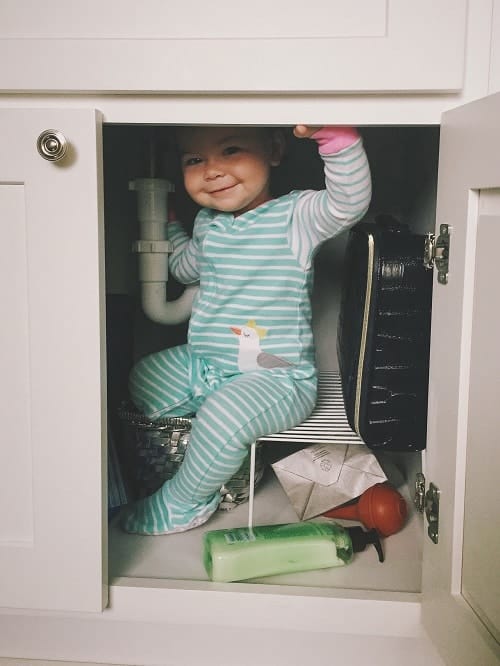 baby smiling inside cabinet