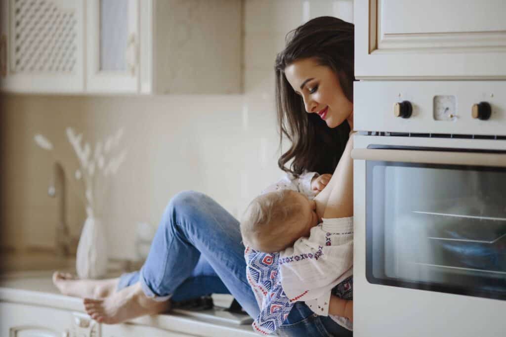 mother is breastfeeding in the kitchen