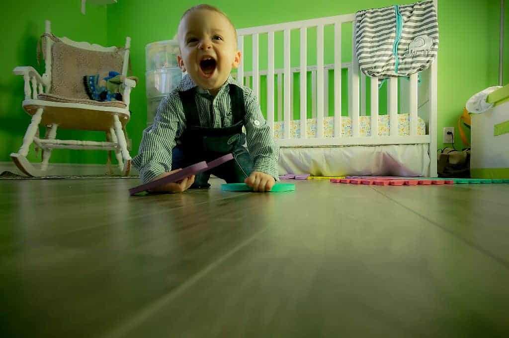 Baby boy happy playing in his green room
