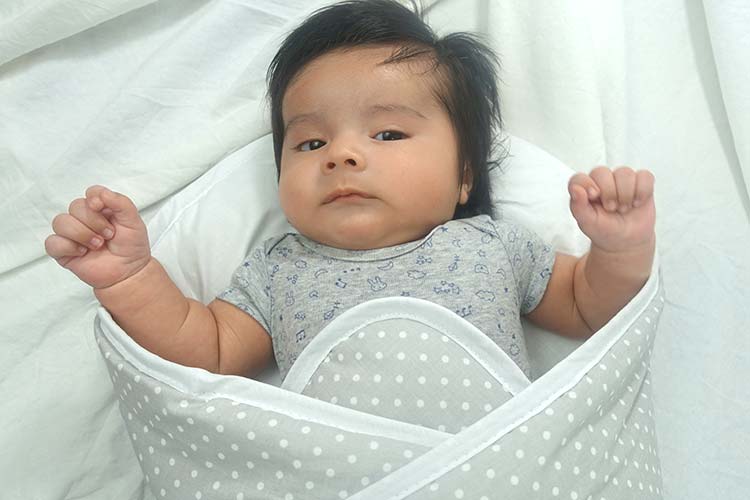 Baby breaking free from bundlebee swaddle wrap