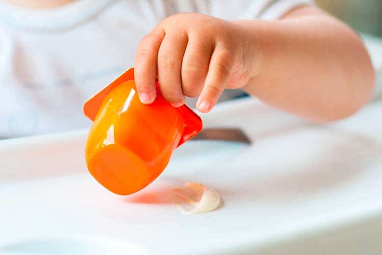 Baby eating a tub of yogurt