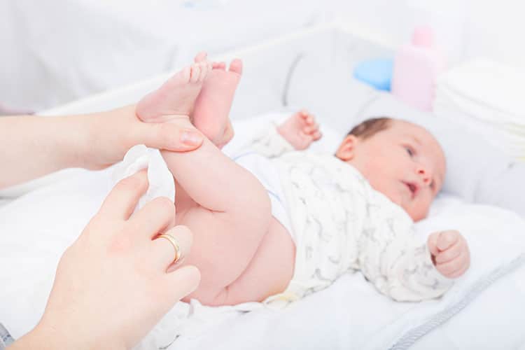 mom wiping baby's bottom with baby wipe