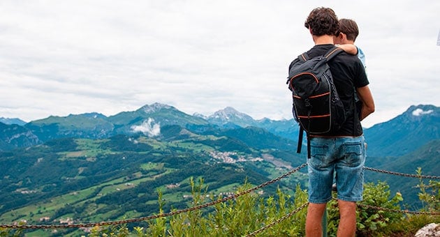 A dad hiking with his diaper bag and baby