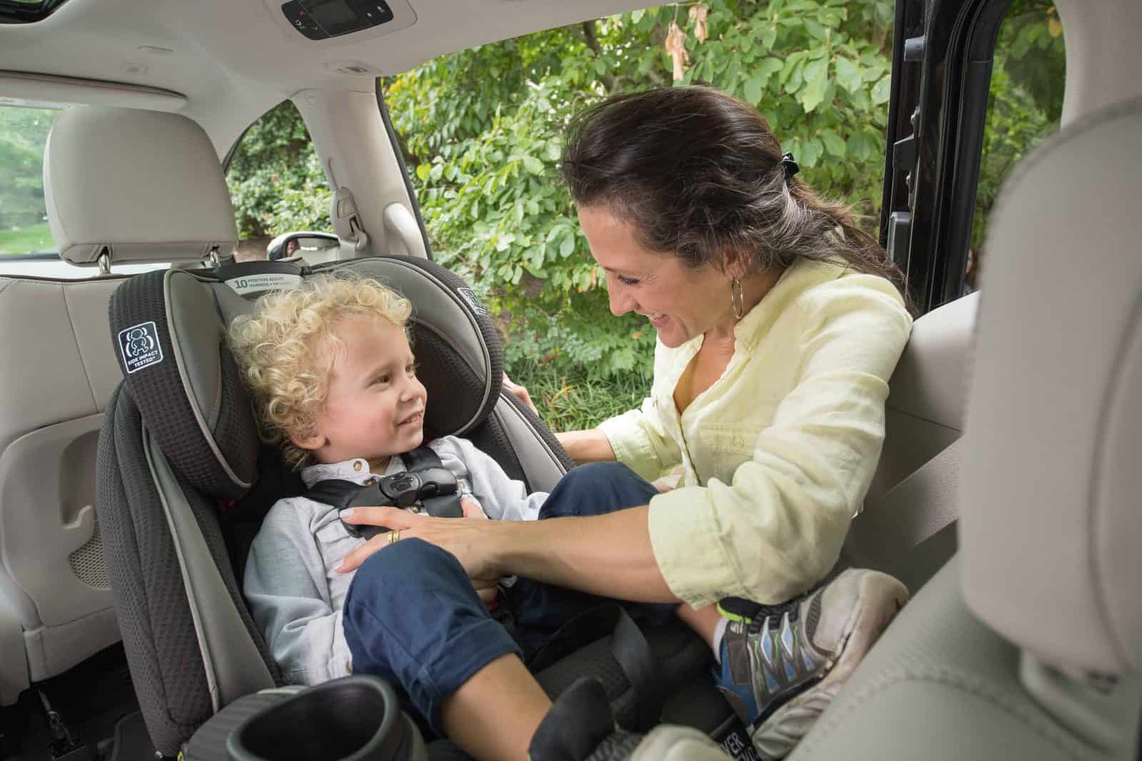 Rear facing toddler with an adult smiling at them
