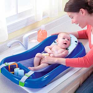 Mom cleaning baby in hammock baby bath tub