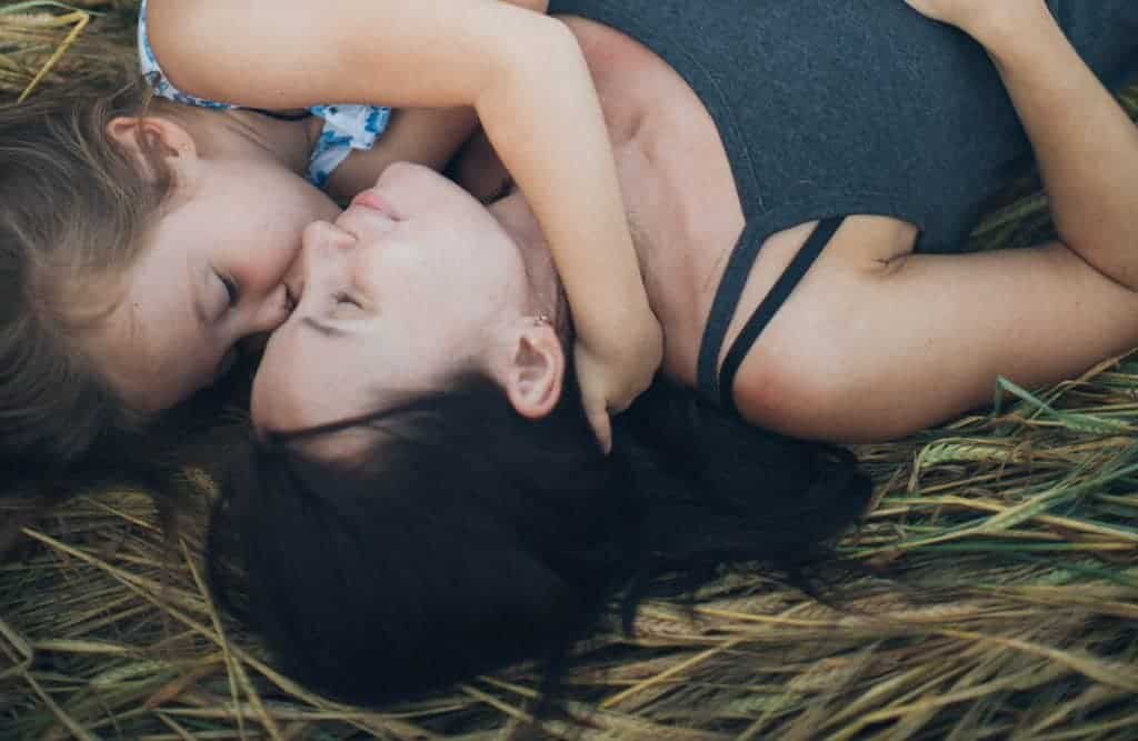 Mother and daughter sleeping in hay