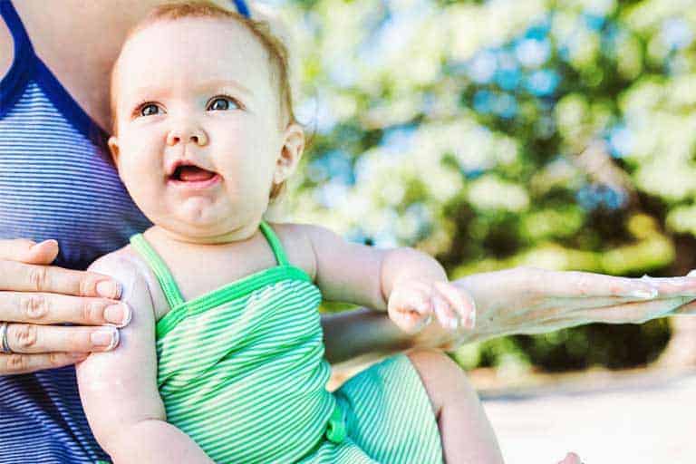 applying organic sunscreen to a baby