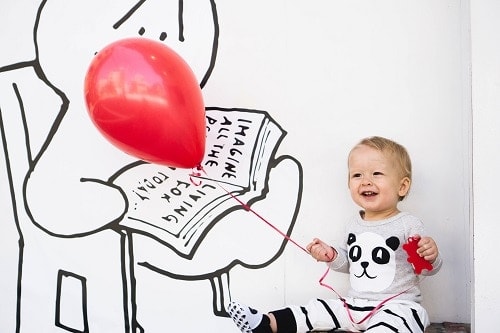 smilling toddler holding balloon