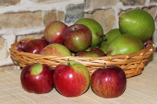 Apples and peaches in a brown basket