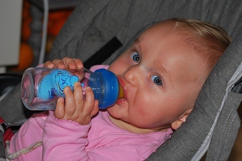 baby drinking water on bottle formula