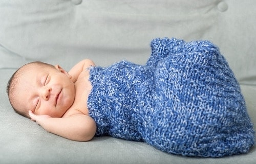 baby sleeeping with blue swaddle