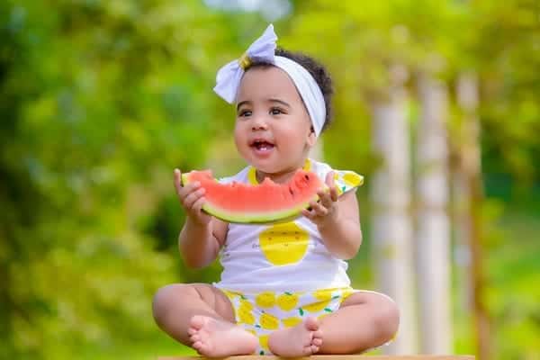 Baby girl eating watermelon