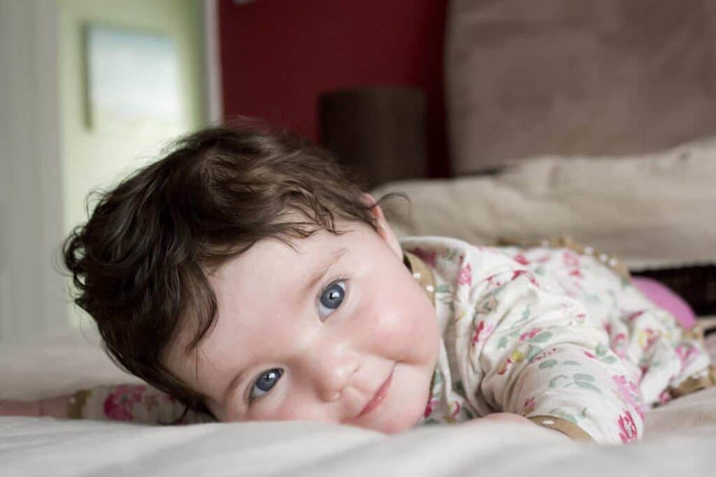 a baby smiles at the camera