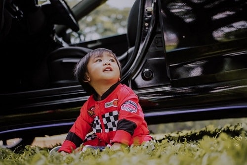 Baby is outside the black car