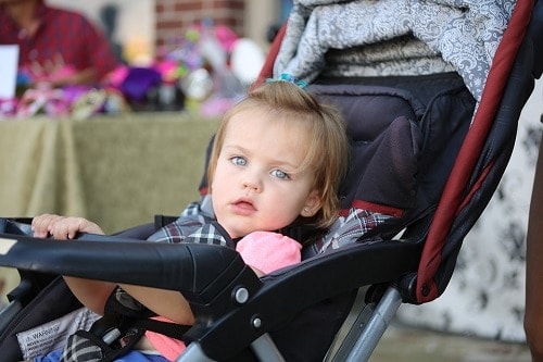 Girl in stroller waring pink shirt