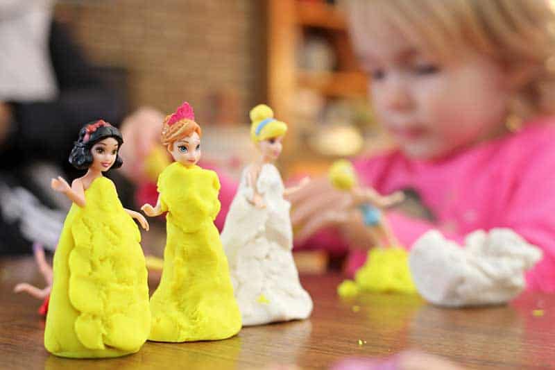 girl playing on the three disney figurine 