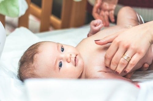 Baby lying in white soft bed