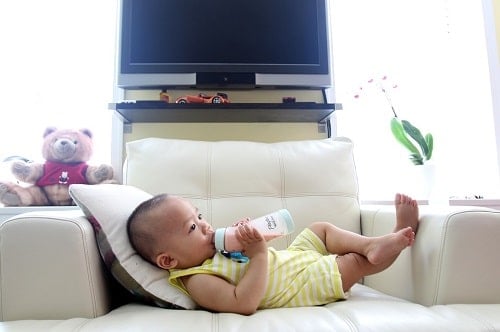 baby drinking milk in couch