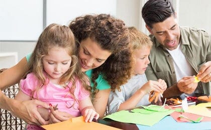 family cutting papers and bonding