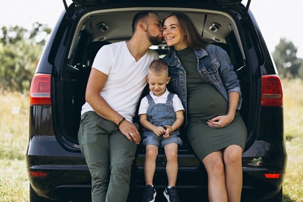 husband with pregnant wife their son sitting car