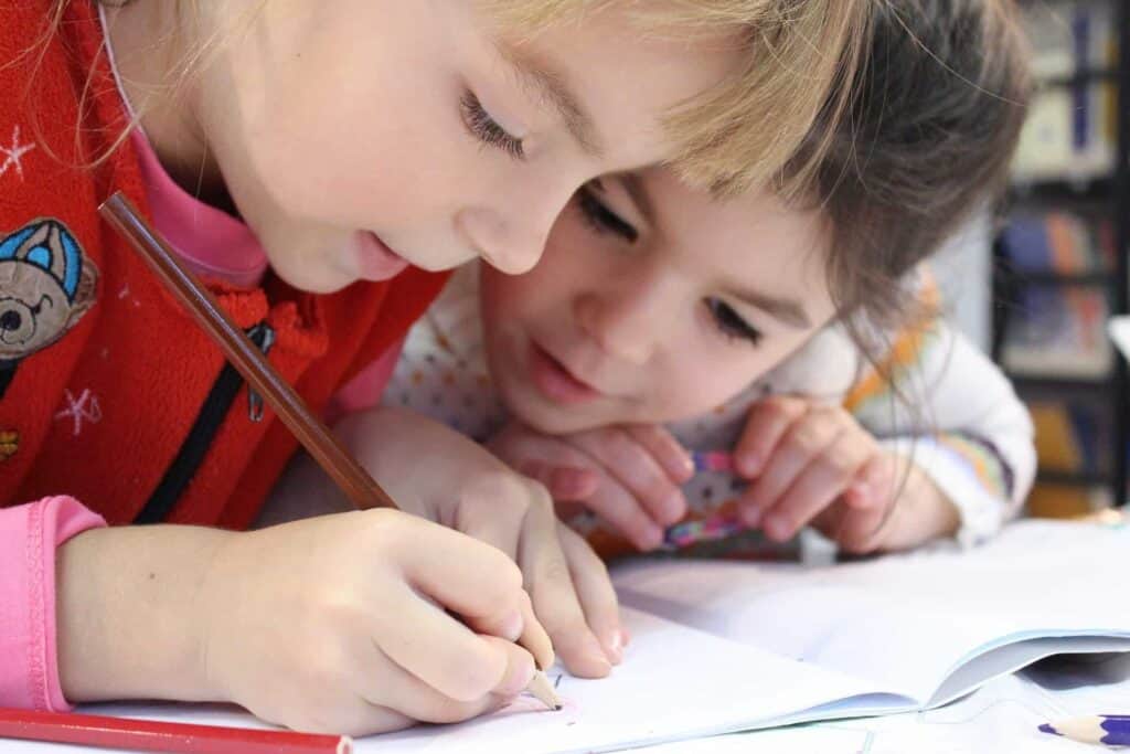 TWo young girls relieve their cabin fever with a workbook