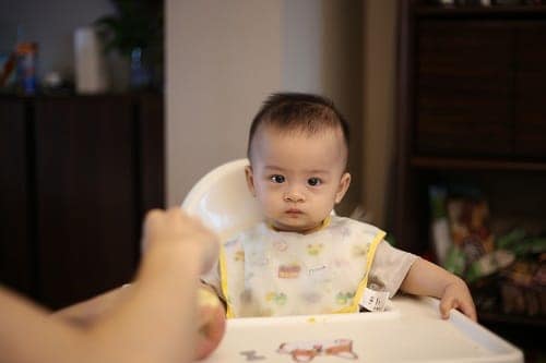 Baby sitting on high chair