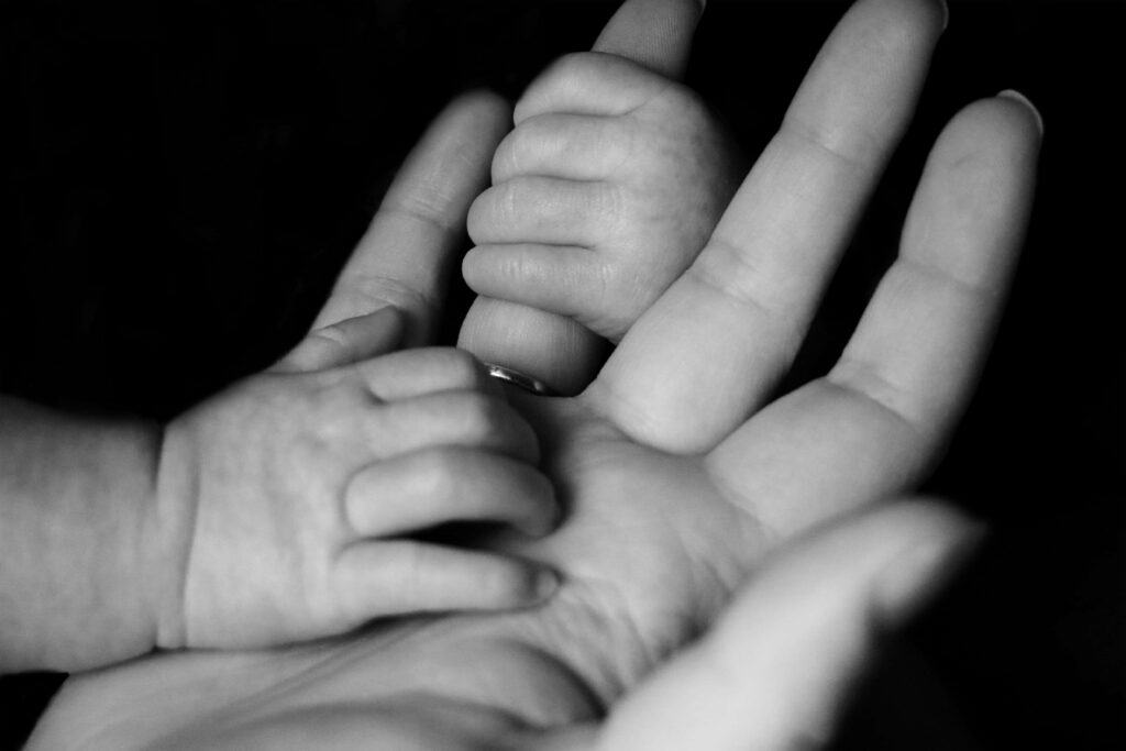 baby hoding persons fingers