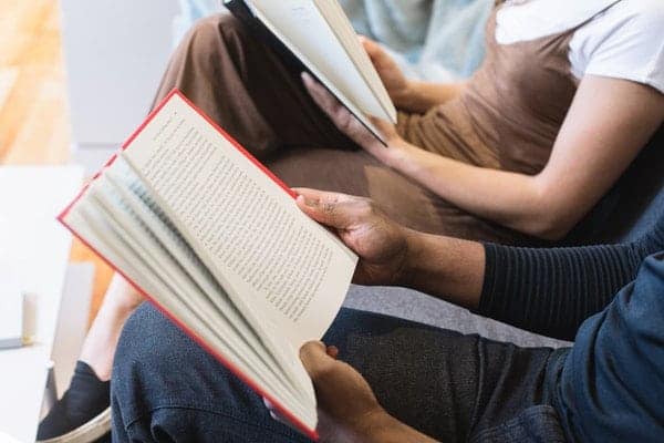 man reading book beside woman-reading book