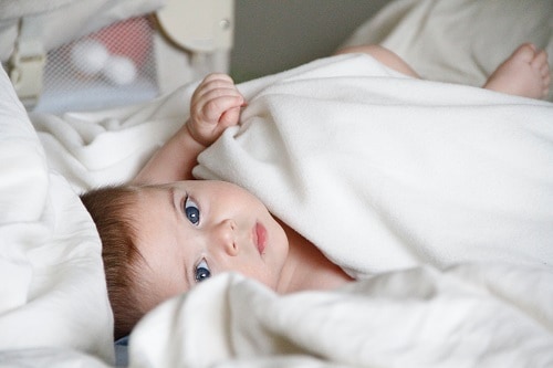 baby lying on a white sheet