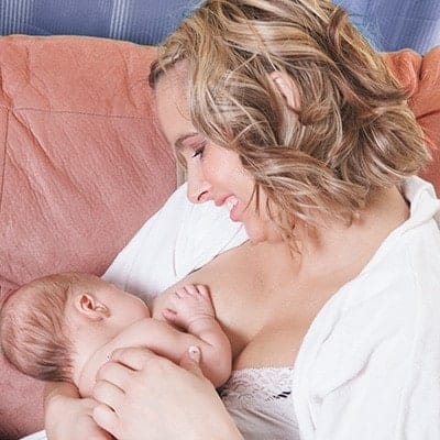 mother breast feeding on a couch