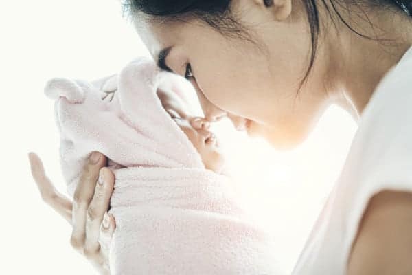 Newborn Baby Sleeping in the hands of mother