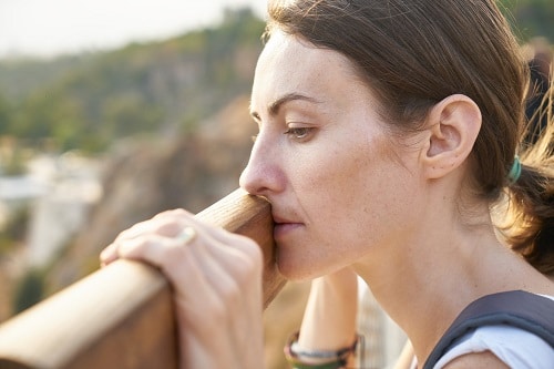 sad woman holding on wood