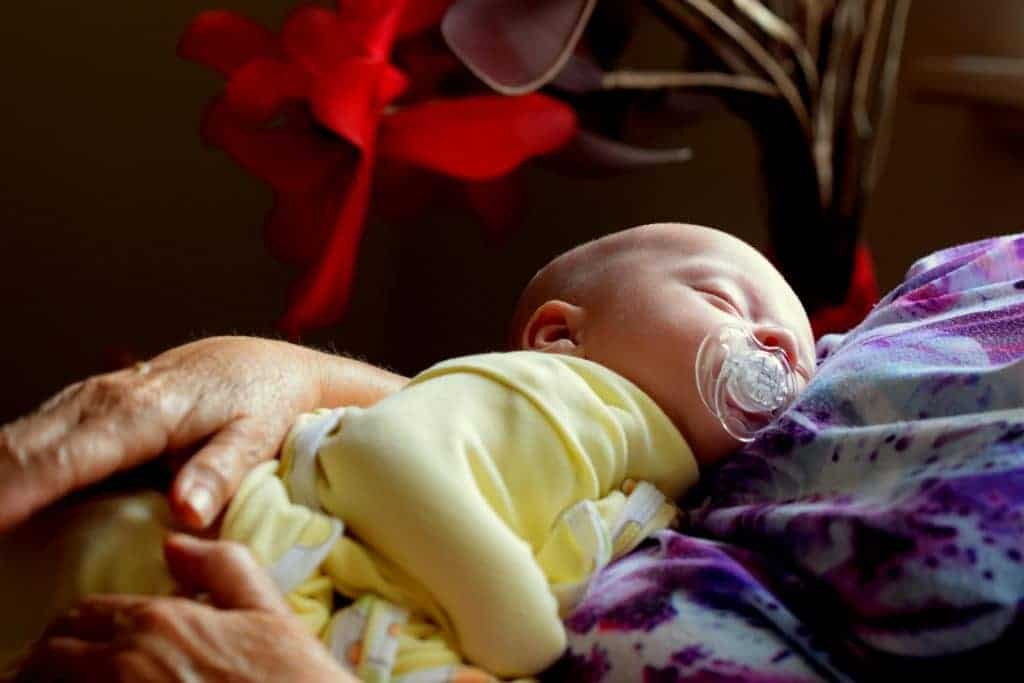 baby sleeping on mother's arm