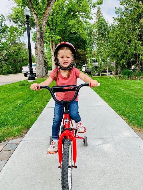 kids playing red bike with training wheels