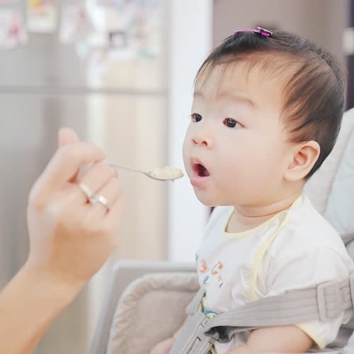 person feed the baby