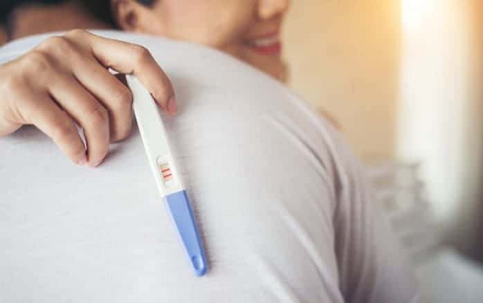 Happy couple smiling after find out positive pregnancy test