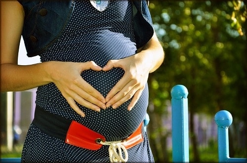 pregnant woman making heart shaped hands