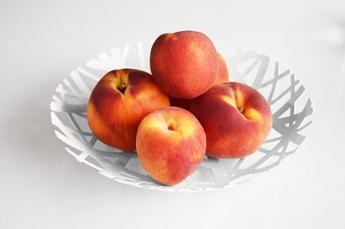 Round white plate of peaches