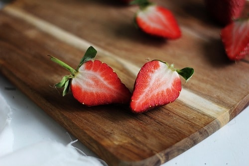 sliced of raspberry on brown wooden board