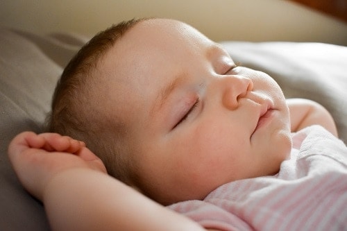 slleping baby on gray cushion