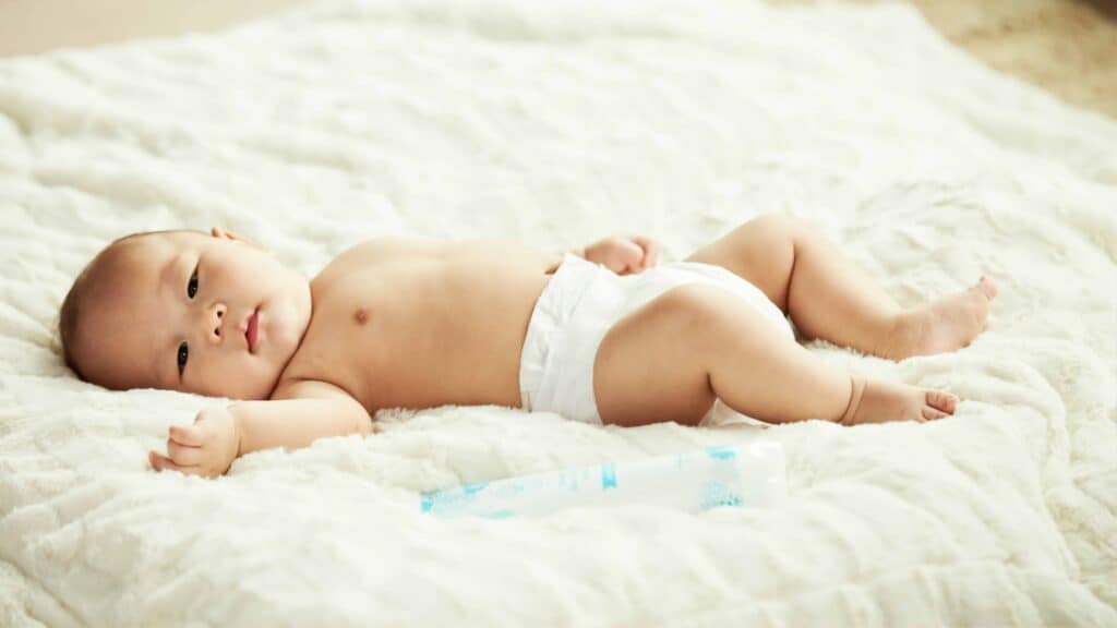 Baby in a diaper on the bed