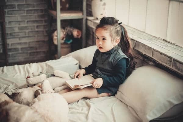 Toddler on Bed reading book